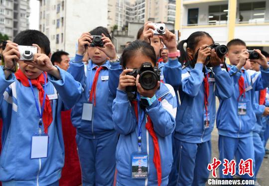 图为摄影希望小学的学生们正沉浸在摄影的世界里。　张斌 摄