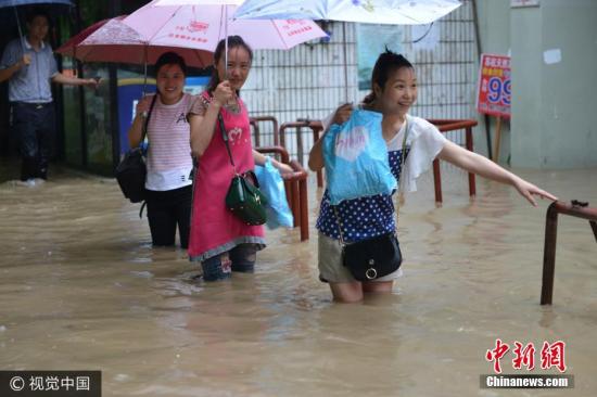 图为南京市雨花台区，市民在水中艰难出行。 文字来源：中国天气网 图片来源：视觉中国