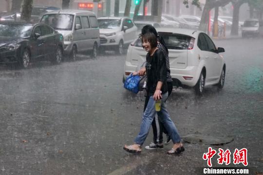 图为突遇降雨的行人。　燕武 摄