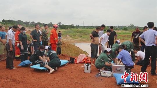 现场急救人员立即对被困车内的落水人员实施抢救。　钟欣 摄