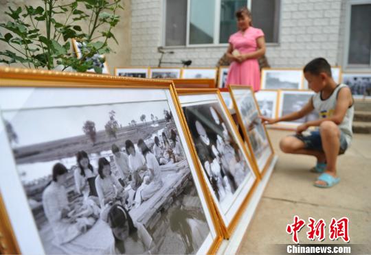 图为群众在赵文岭家中参观马本斋与回民支队事迹图片展。　苑立伟 摄